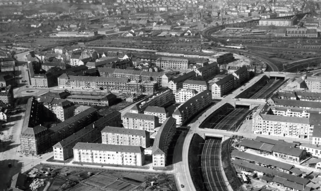 Luftaufnahme des Dreierensembles entlang der Seebahnlinie aus dem Jahr 1930. Vor der ABZ Kanzlei steht 
heute das 1966 fertiggestellte Lochergut (Stadtzürcher Heimatschutz 2012, 16–17/Baugeschichtliches Archiv Zürich).
